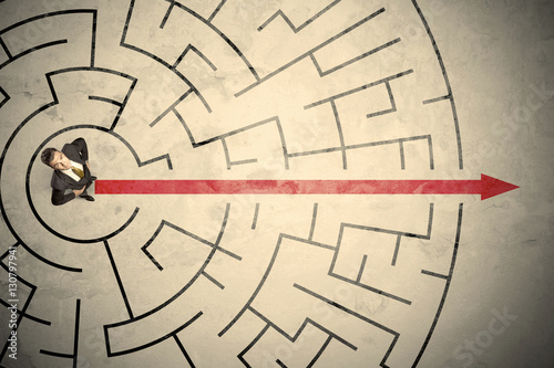 Business person standing in the middle of a circular maze