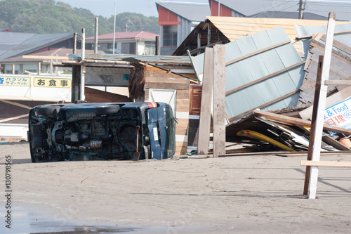 台風による強風で横転した海岸にある自動車と崩壊した海の家 2