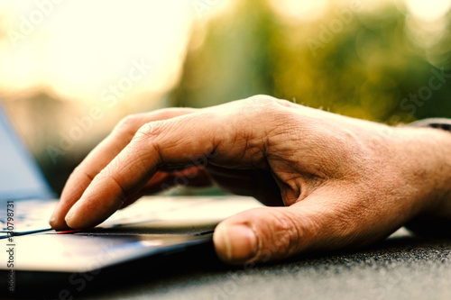 Hand auf Tastatur eines Laptops / Arbeit im Freien / Mobile Ofifice