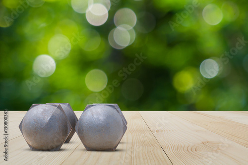 Old dumbbells on wooden floor side view on blurred bokeh background, fitness concept
