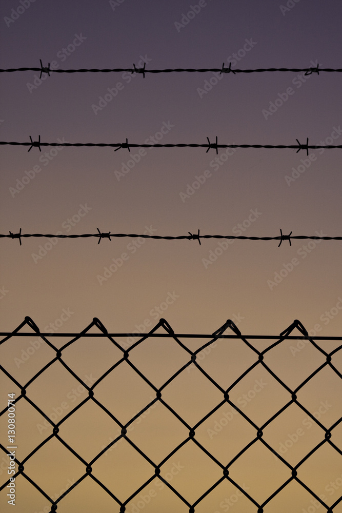 Deutschland. Niedersachsen. Delmenhorst. Zaun und Stacheldraht im Sonnenuntergang. Deutschland. Niedersachsen. Delmenhorst. Zaun und Stacheldraht im Sonnenuntergang.