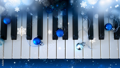 Piano keyboard with shiny blue and silver balls, glitter, snowflakes. View from above. Christmas festival