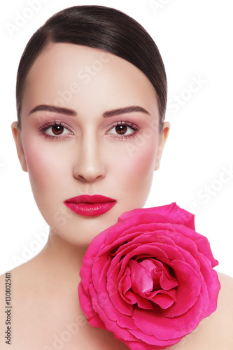 Portrait of young beautiful healthy woman with fancy pink rose over white background
