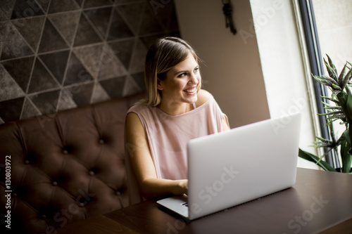 Young woman with laptop sit...