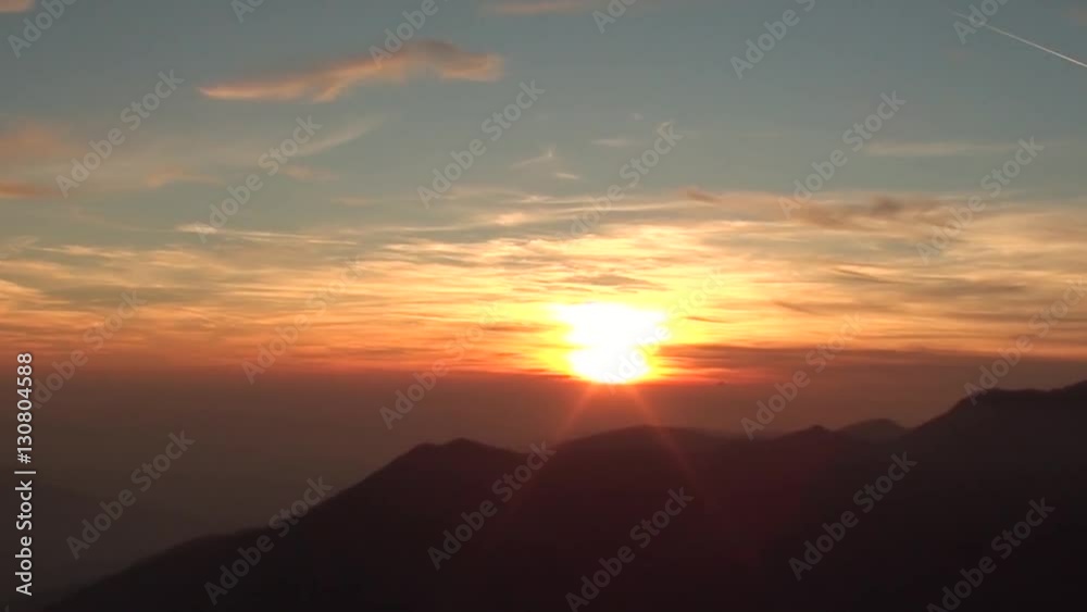 Fiery sunset from mountain pick with thin glazes in the sky evening. Fall season. Orobie alps. The summit of Mount Rena. Bergamo Italy. Fiery sunset from mountain pick with thin glazes in the sky evening. Fall season. Orobie alps. The summit of Mount Rena. Bergamo Italy.