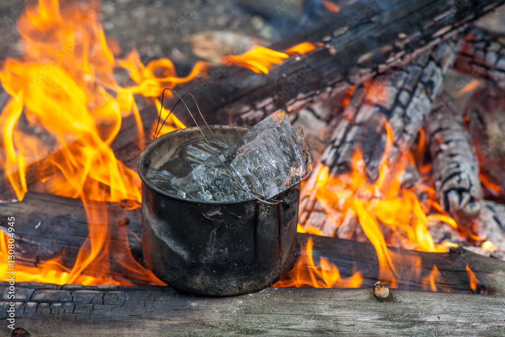 Cooking in the nature. Cauldron with ice on fire in forest. Cooking in the nature. Cauldron with ice on fire in forest.