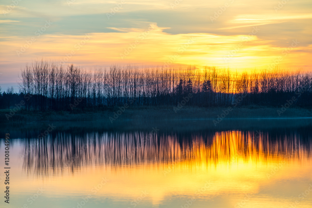 Fototapeta premium Sunset on the lake. Reflections in water.