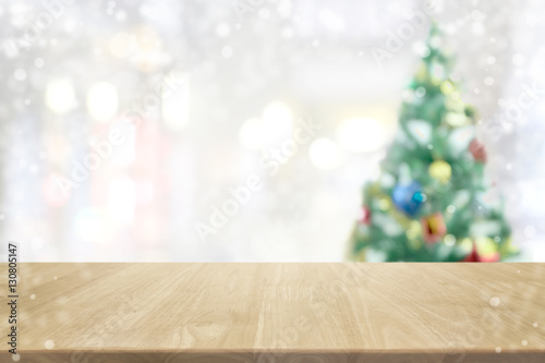 Wood table top on blur with bokeh christmas tree background with vintage filter - can be used for display or montage your products