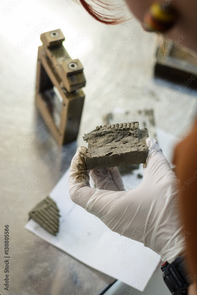 Civil engineer performing a laboratory test for shear strength determination and observing the soil after testing