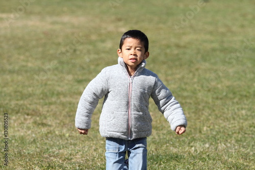 芝生の上を走る小学生(1年生)