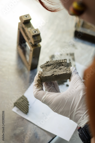 Obraz na płótnie Civil engineer performing a laboratory test for shear strength determination and observing the soil after testing w salonie