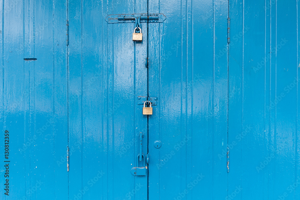 Fototapeta premium Blue wooden door with the three padlock
