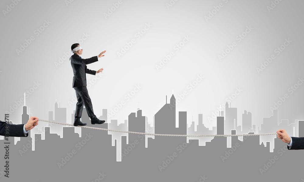 Business concept of risk support and assistance with man balancing on rope Business concept of risk support and assistance with man balancing on rope
