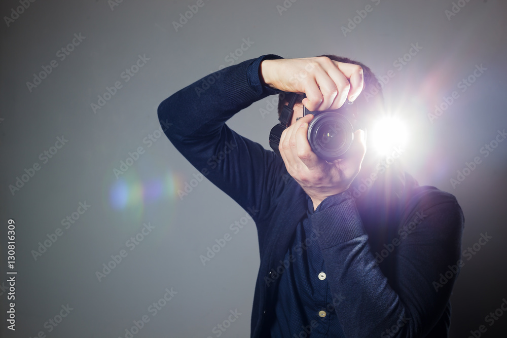 Photographer takes a picture in the studio using a flash - obrazy, fototapety, plakaty 