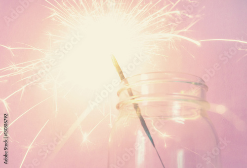sparkler in bottle on the pink background
