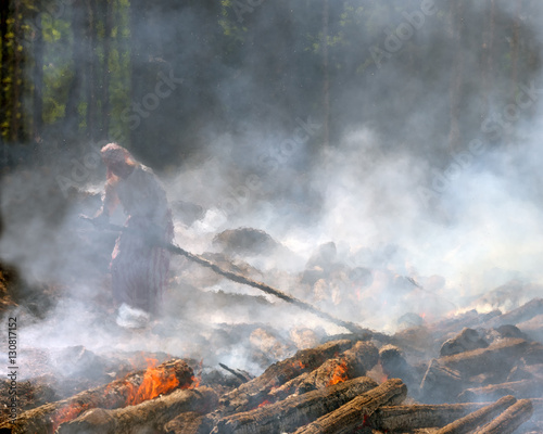 Traditional slashing and burning in Koli National Park with people being protected with old fashioned light-coloured linen clothes and scarfs