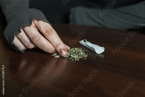 Addict hands making marijuana jamb closeup.