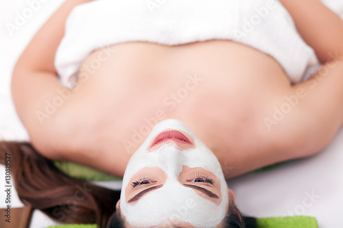 Spa concept. Hand applying nourishing mask on female face in spa salon