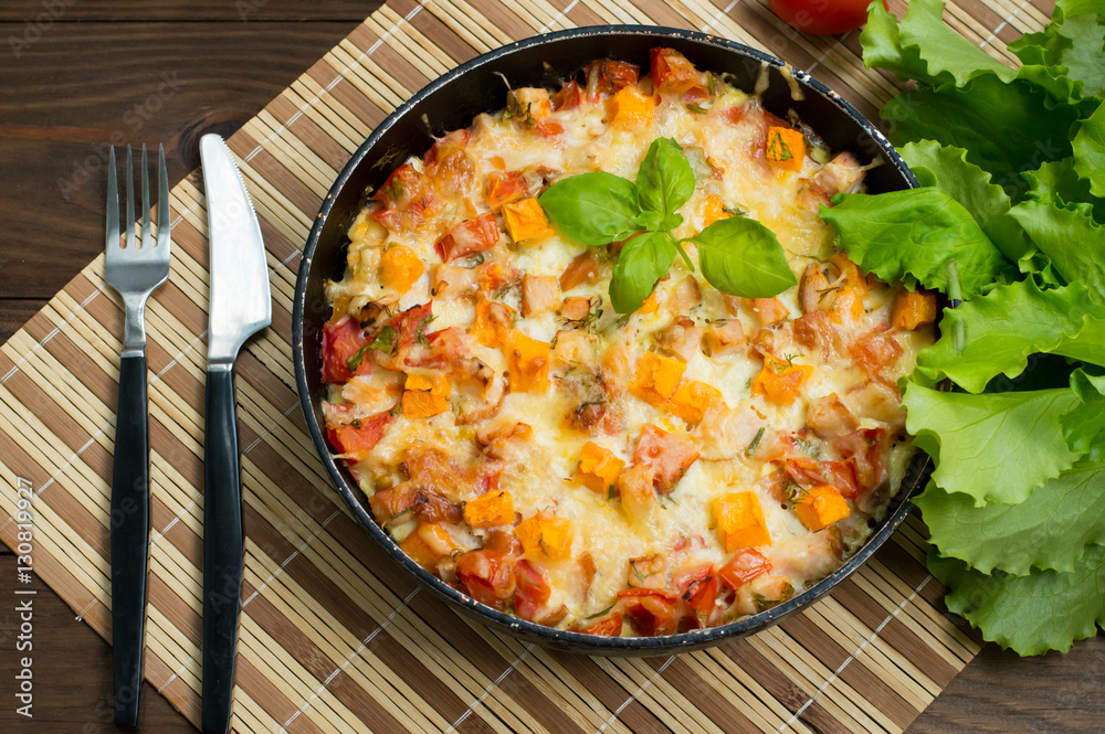 Casserole with chicken and pumpkin in a pan. Wooden rustic background. Top view. Close-up Casserole with chicken and pumpkin in a pan. Wooden rustic background. Top view. Close-up
