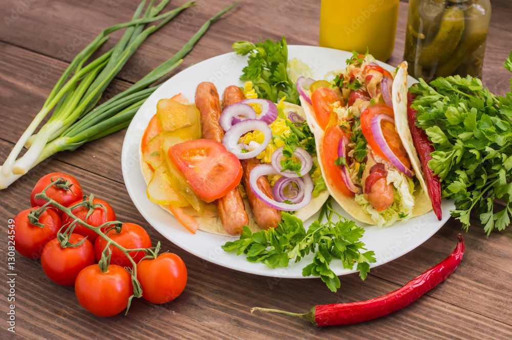 Ingredients for a picnic consisting of vegetables and sausages grilled on wooden rustic background, top view. Close-up Ingredients for a picnic consisting of vegetables and sausages grilled on wooden rustic background, top view. Close-up