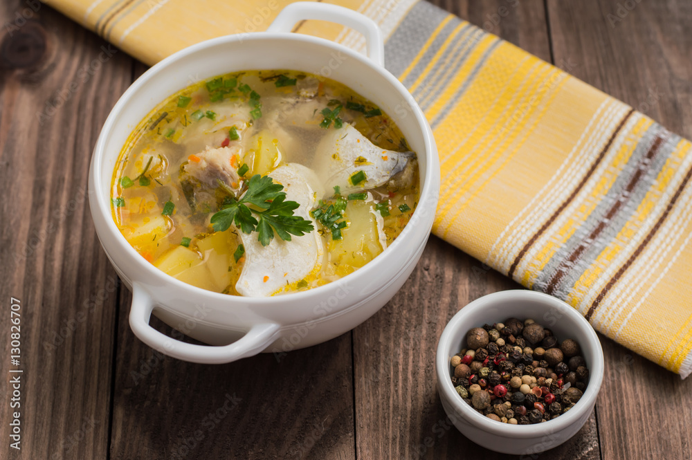 Fresh fish soup with ingredients and spices for cooking. Wooden background. Top view. Close-up Fresh fish soup with ingredients and spices for cooking. Wooden background. Top view. Close-up