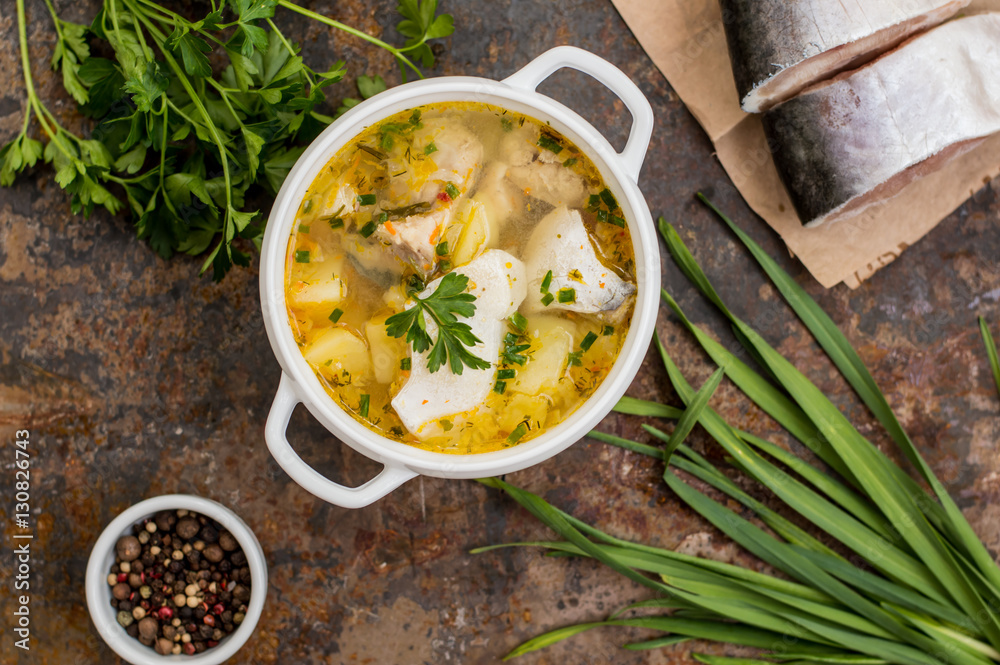 Fresh fish soup with ingredients and spices for cooking. Wooden background. Top view. Close-up