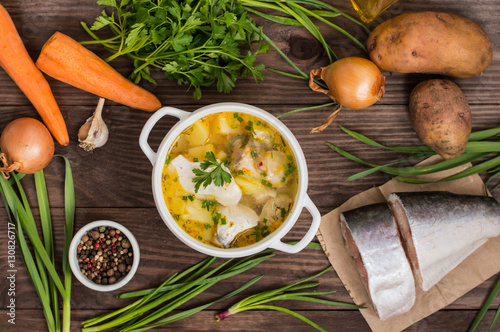 Fresh fish soup with ingredients and spices for cooking. Wooden background. Top view. Close-up