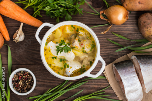 Fresh fish soup with ingredients and spices for cooking. Wooden background. Top view. Close-up