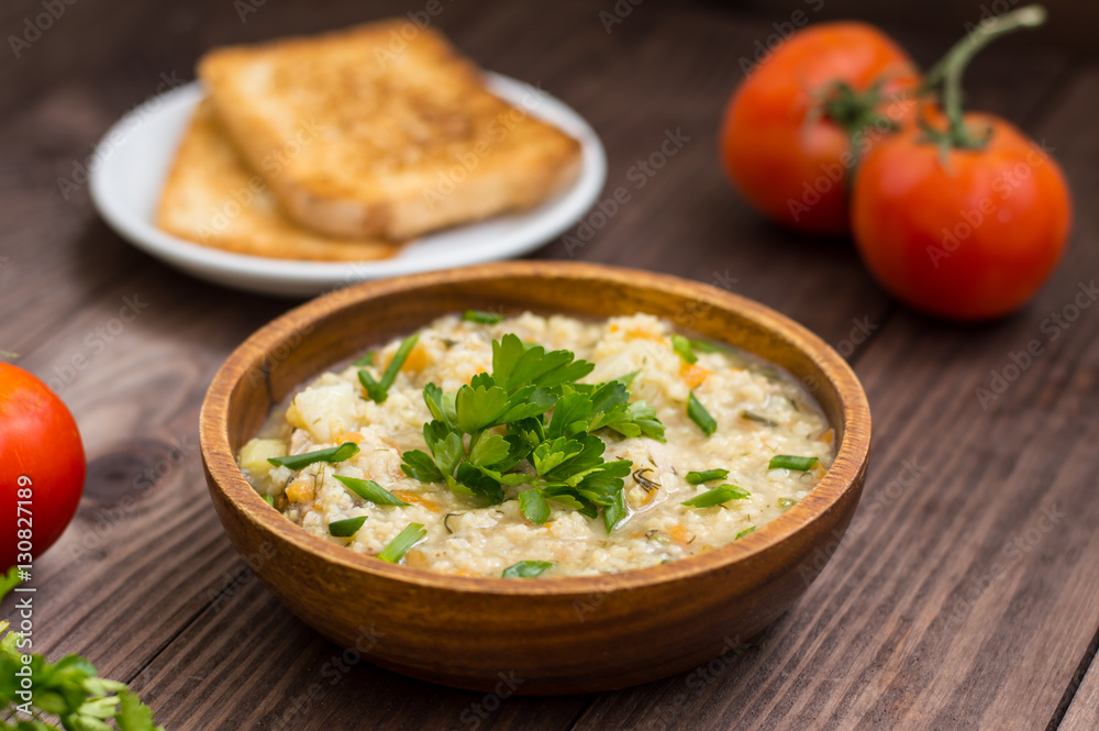 Wheat porridge with meat prepared on a fire in wooden plate rustic table. Top view Wheat porridge with meat prepared on a fire in wooden plate rustic table. Top view