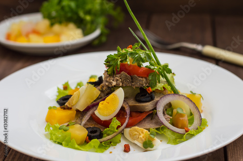 Salad with tongue on the wooden background