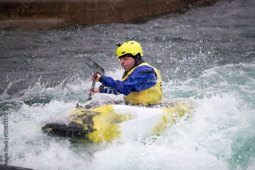Man in kayak paddling hard in rough water