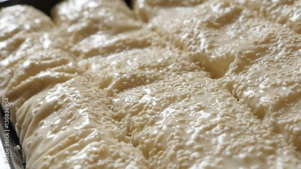 Sesame sprinkling over oiled homemade filo pie with cheese and spinach in slow motion 1080p FullHD footage - Thin sheets of dough rolled with filling in baking tray slow-mo 1920X1080 HD panning video Sesame sprinkling over oiled homemade filo pie with cheese and spinach in slow motion 1080p FullHD footage - Thin sheets of dough rolled with filling in baking tray slow-mo 1920X1080 HD panning video
