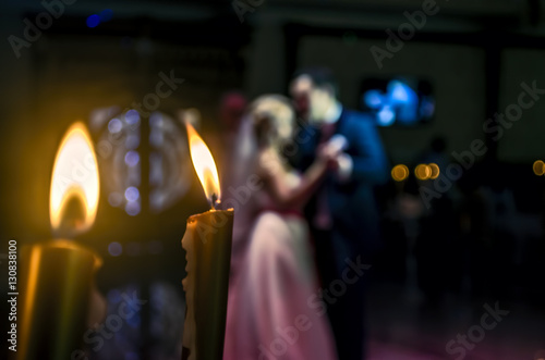  romantic dancing couple  defocused on the background and golden candles or wedding couple at the party, blurred by purpose