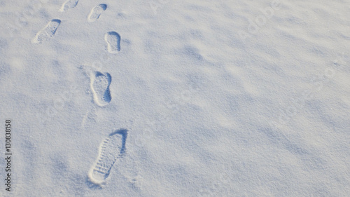 After snowing, people's footprints are left on the snowfield which imply the path of people's life. photo