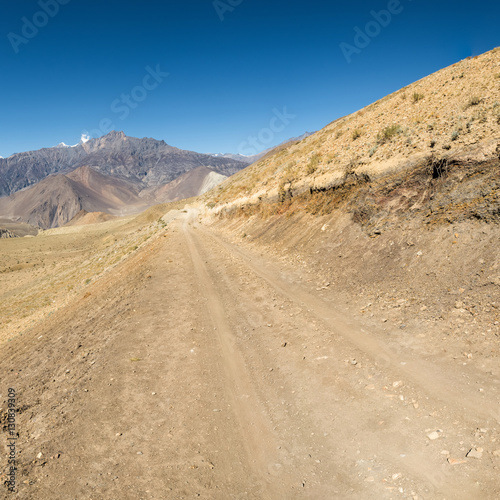 Dirt road through arid mountain wastelands.