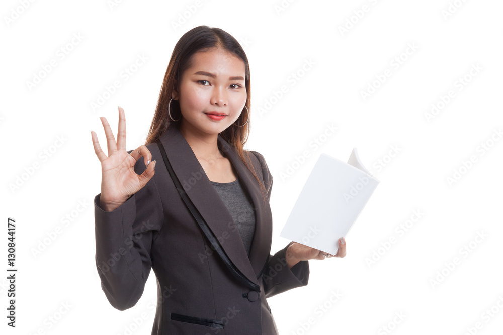 Young Asian business woman show OK with a book. Young Asian business woman show OK with a book.