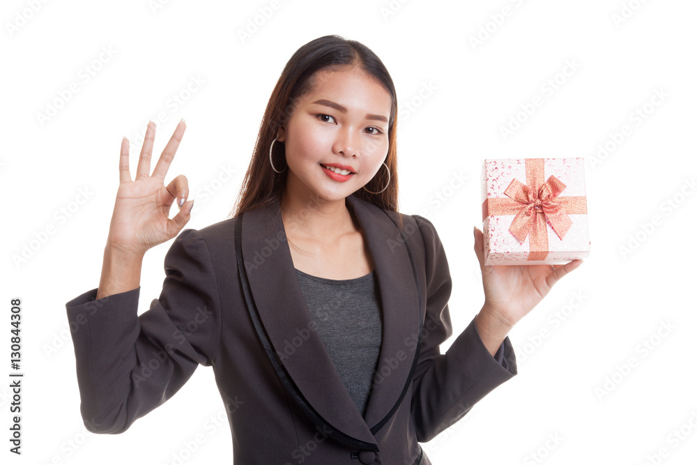 Young Asian business woman show OK with a gift box. Young Asian business woman show OK with a gift box.
