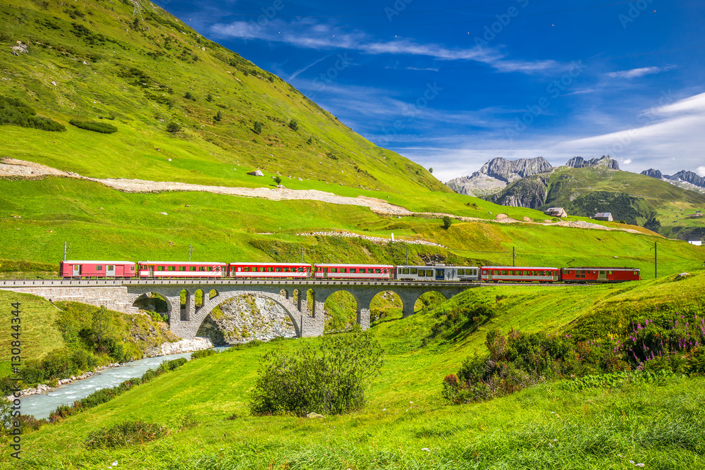 Fototapeta premium Pociąg Matterhorn - Gotthard - Bahn na moście wiaduktu w pobliżu Andermatt w Alpach Szwajcarskich