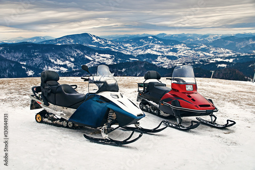 Принти на полотні Two snowmobiles on beautiful winter mountains landscape and stratocumulus clouds background