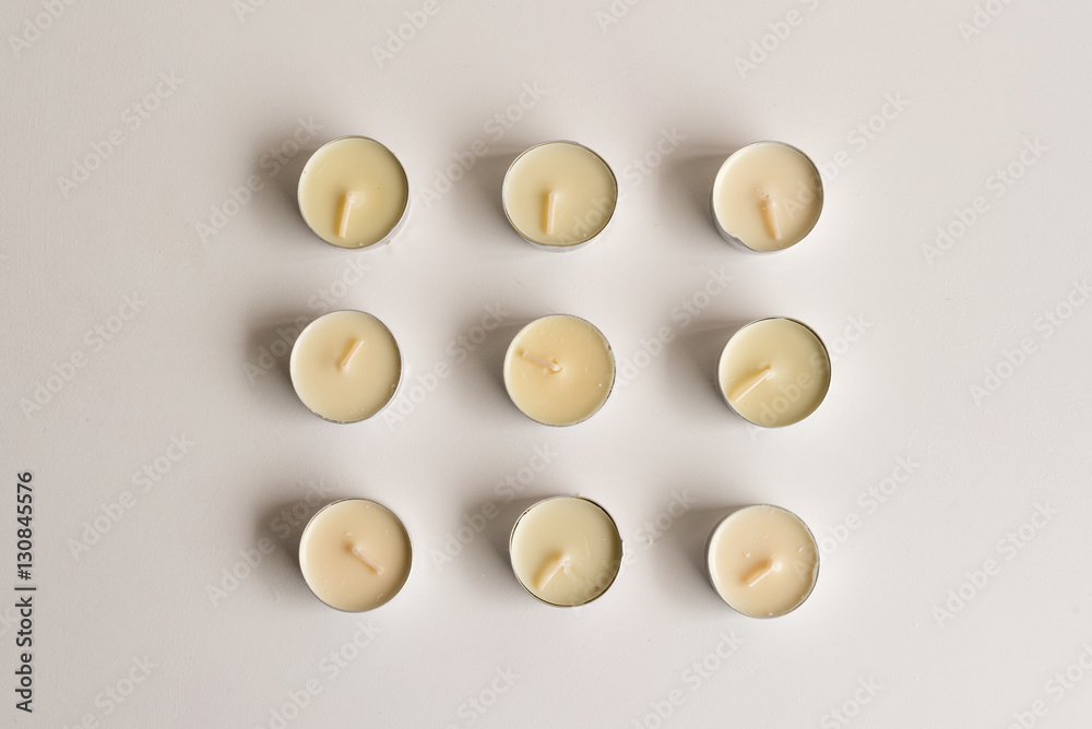 High angle view of unlit tealights arranged on white table
