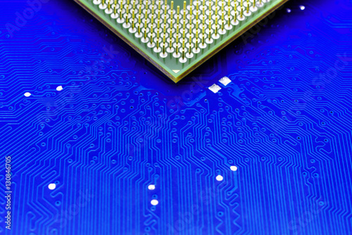 Technological background with blue computer motherboard and central processing unit closeup