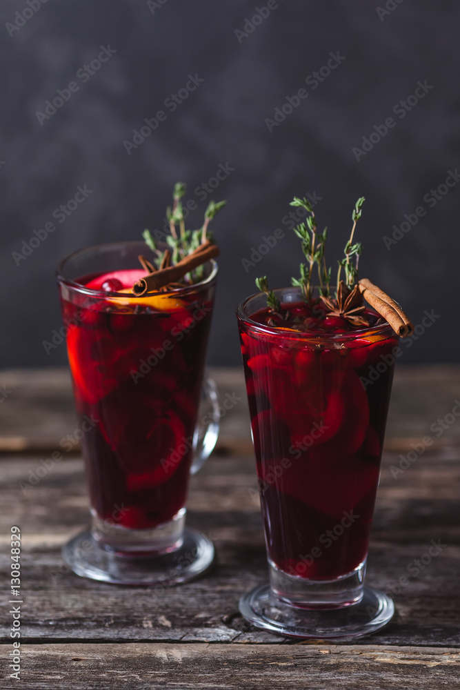 Two glasses of hot mulled wine on a dark background. Spices, oranges and fir cones Two glasses of hot mulled wine on a dark background. Spices, oranges and fir cones