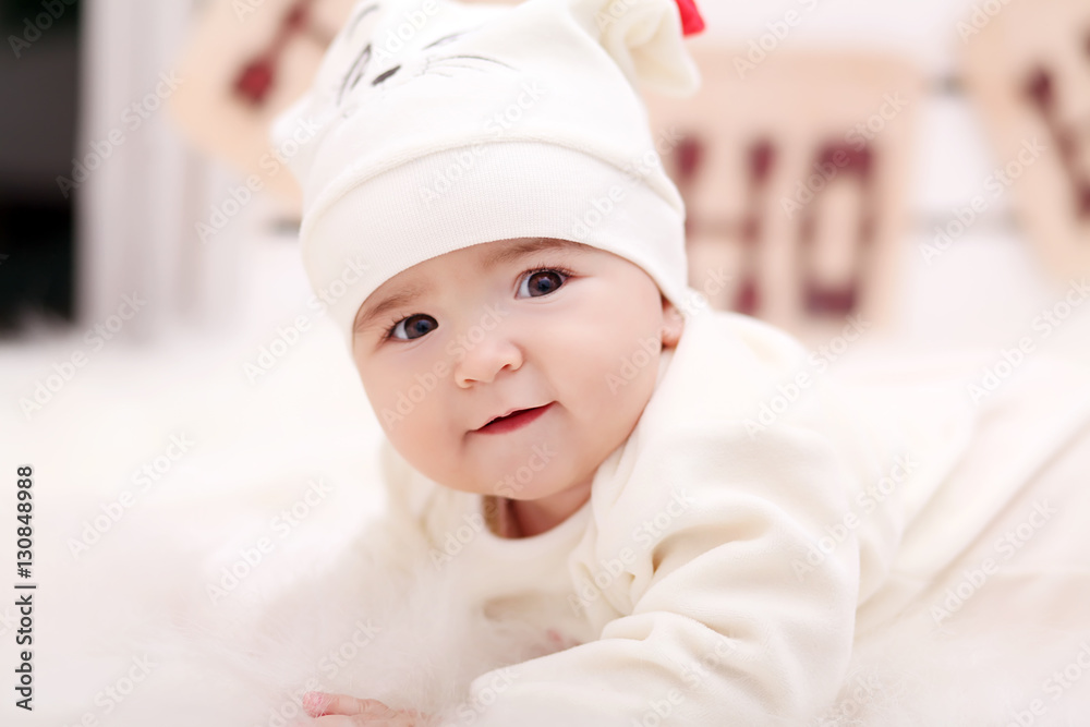 baby girl in Santa Claus hat with gifts under Christmas tree baby girl in Santa Claus hat with gifts under Christmas tree