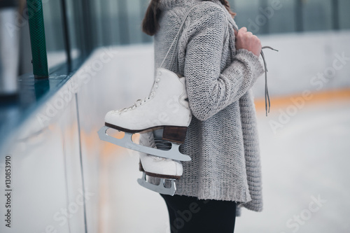 Woman at ice-skating rink holding skates.