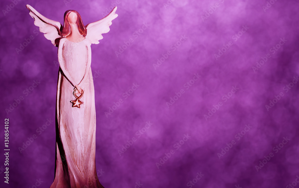Fototapeta premium Christmas angel on a purple bokeh background