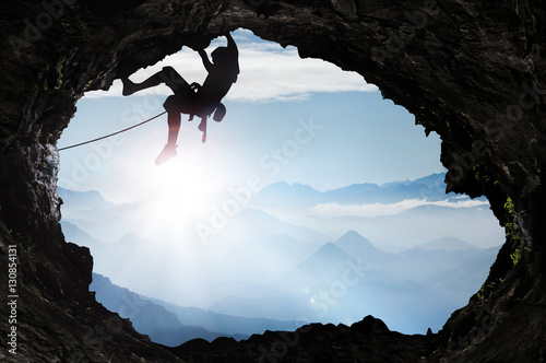 Fototapeta Bergsteiger im Hochgebirge an einem Höhlenausgang
