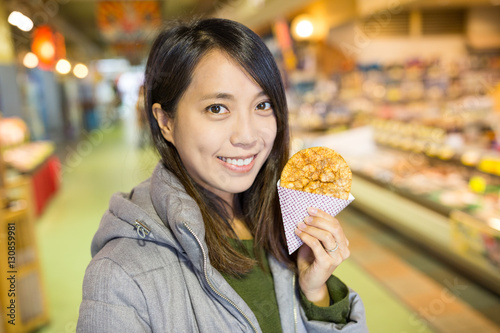 Woman holding a rice cracker in fish market