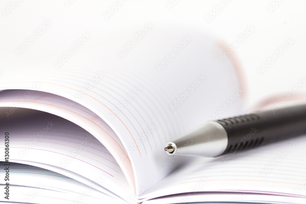 selective focus of ball pen on opened lined diary book selective focus of ball pen on opened lined diary book