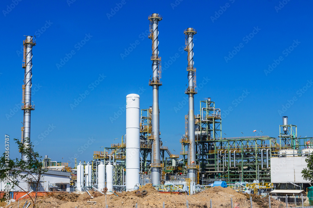Fototapeta premium Refinery tower in petrochemical industrial plant with cloudy sky