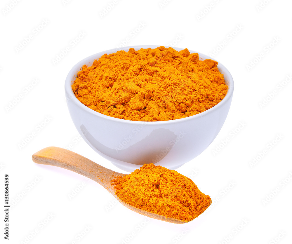 dry turmeric powder in white bowl and wooden spoon isolated on w dry turmeric powder in white bowl and wooden spoon isolated on w
